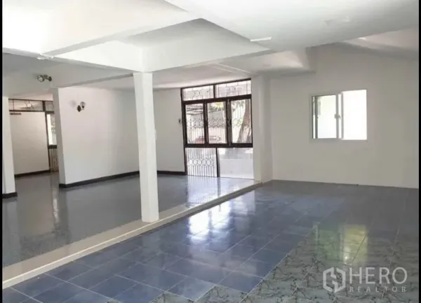 บ้าน ให้เช่าในLat Phrao, Bangkok - พื้นที่นั่งเล่นชั้นล่างแบบโอเพ่น พื้นกระเบื้องหลายโทน เสาโครงสร้าง และหน้าต่างพร้อมเหล็กดัด