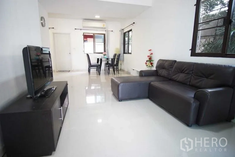 ทาวน์เฮาส์ ให้เช่าในSuan Luang, Bangkok - ห้องนั่งเล่นกว้าง โซฟาหนังรูปตัวแอล และชั้นวางทีวี