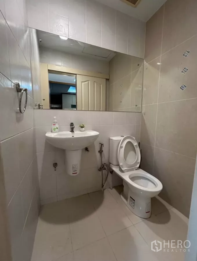Townhouse for rent in Wang Thonglang, Bangkok - Compact guest bathroom with white sink, toilet and wide mirror
