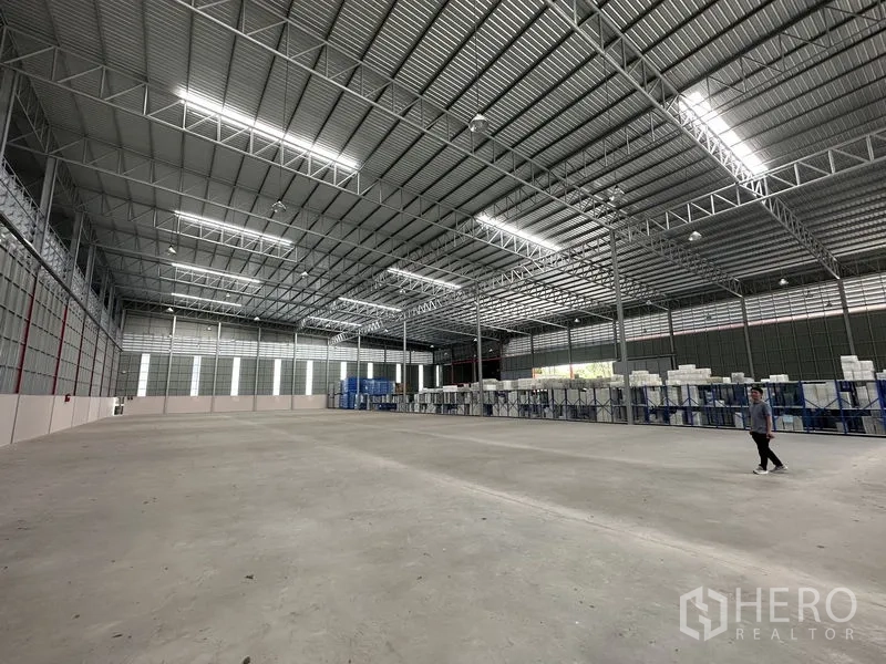 Factory for rent in Chachoengsao - Wide factory interior showing racking and high‑bay lighting with generous circulation space.