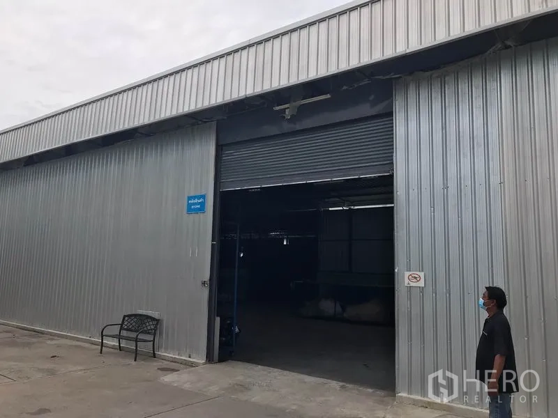 คลังสินค้า ให้เช่าในMueang Chon Buri, Chon Buri - ด้านหน้าโกดังผนังเมทัลชีท ประตูม้วนขนาดใหญ่ และลานทางเข้าออกกว้าง