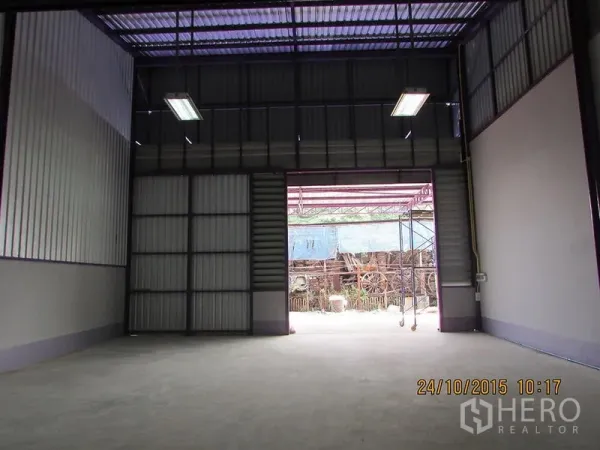货栈 出租在Bang Khen, Bangkok - 大型金属卷闸门与明亮的装卸区，通向院子。