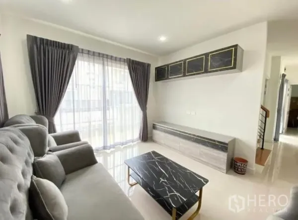 Detached House for rent or sale - Living area with built-in TV cabinet, marble-top coffee table and sliding glass doors to the patio.