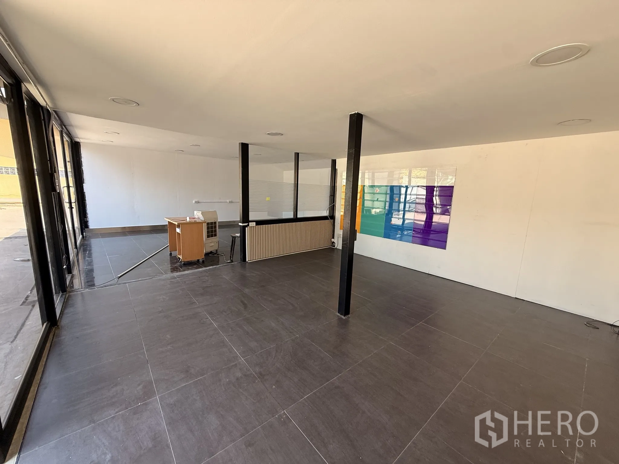 คลังสินค้า for rent in Lat Krabang, Bangkok - มุมมองอีกด้านของสำนักงานโปร่งโล่ง ผนังกระจก เสากลาง และพื้นกระเบื้องมันวาว