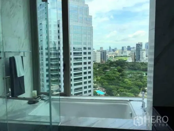 公寓 出租在Bang Rak, Bangkok - 大理石浴室，浴缸临窗，可眺望曼谷天际线与绿地公园景观。