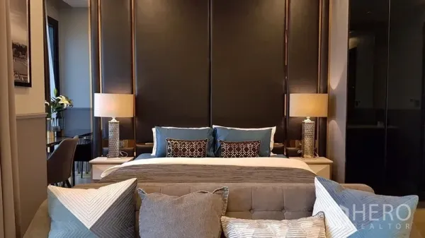 คอนโด ให้เช่าในWatthana, Bangkok - ห้องนอนสไตล์อบอุ่น ผนังหัวเตียงบุ โคมไฟข้างเตียงคู่ และโซฟาสีเท้าหน้าปลายเตียง