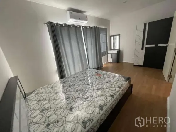 Townhouse for rent or sale in Phasi Charoen, Bangkok - Bright bedroom with air-conditioning, grey curtains, wood floors and vanity.