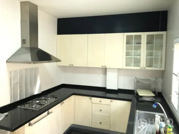 独立式住宅 出租或出售在Bang Kapi, Bangkok - U 型厨房，黑色花岗岩台面，燃气灶与不锈钢烟机。