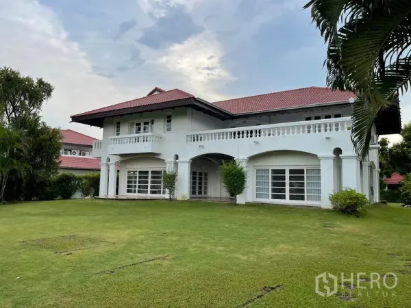 Detached House for rent in Bang Phli, Samut Prakan - Two-storey white villa with a red tile roof overlooking a vast manicured lawn.