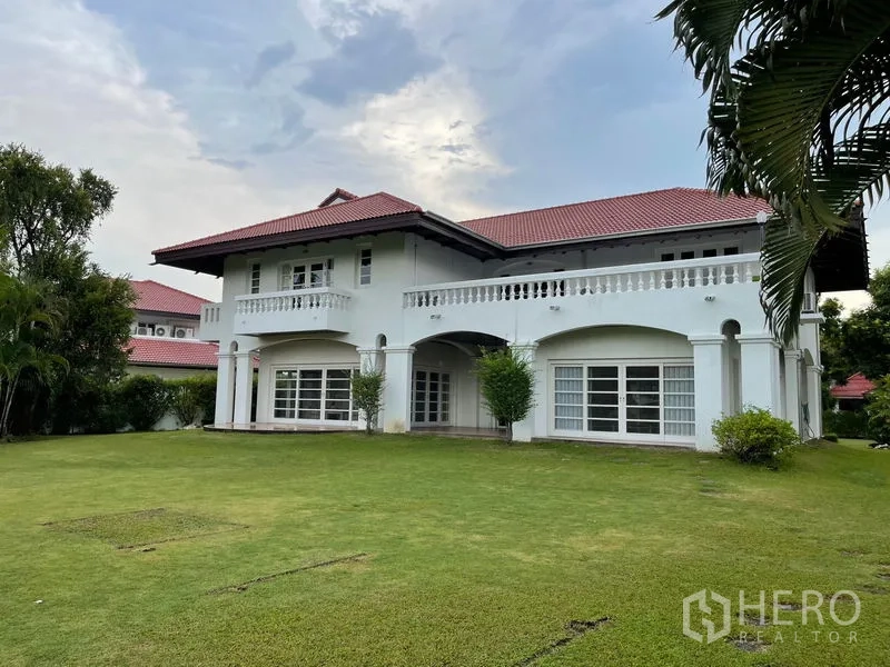 Detached House for rent in Bang Phli, Samut Prakan - Two-storey white villa with a red tile roof overlooking a vast manicured lawn.