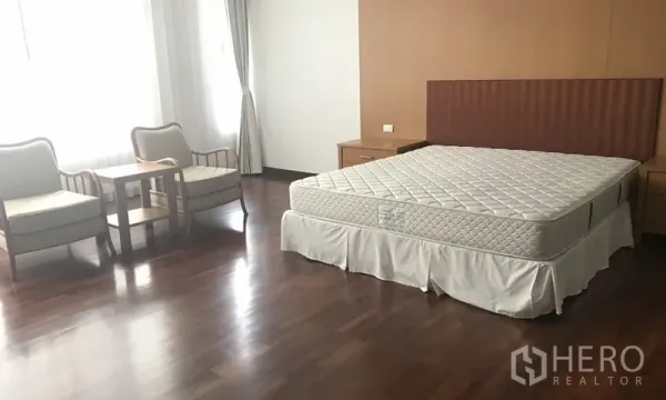 อพาร์ทเมนท์ ให้เช่าในWatthana, Bangkok - ห้องนอนกว้างพร้อมเตียง มุมนั่งเล่น พื้นไม้ และแสงธรรมชาติ