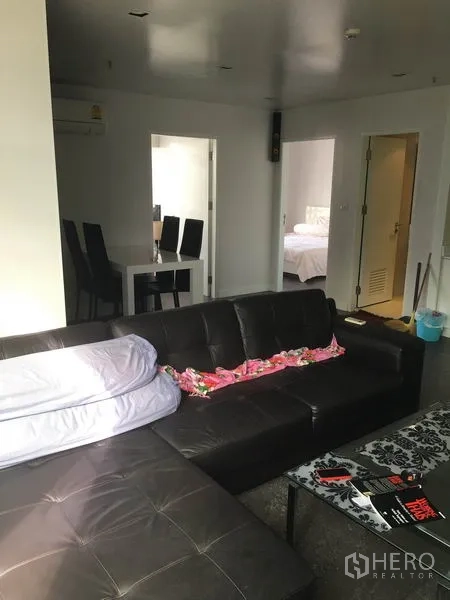 คอนโด ให้เช่าในWatthana, Bangkok - มุมห้องนั่งเล่น โซฟามุม โต๊ะกลาง และประตูไปยังห้องนอนและพื้นที่รับประทานอาหาร