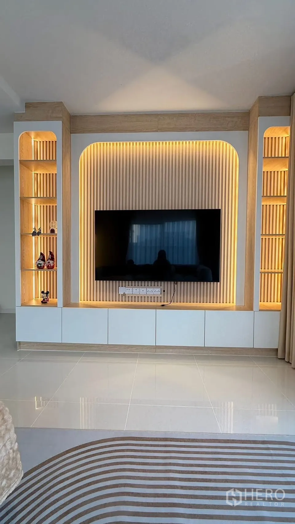 Detached House for rent in Bang Phli, Samut Prakan - Living room TV wall with illuminated built-in shelves and a large screen.