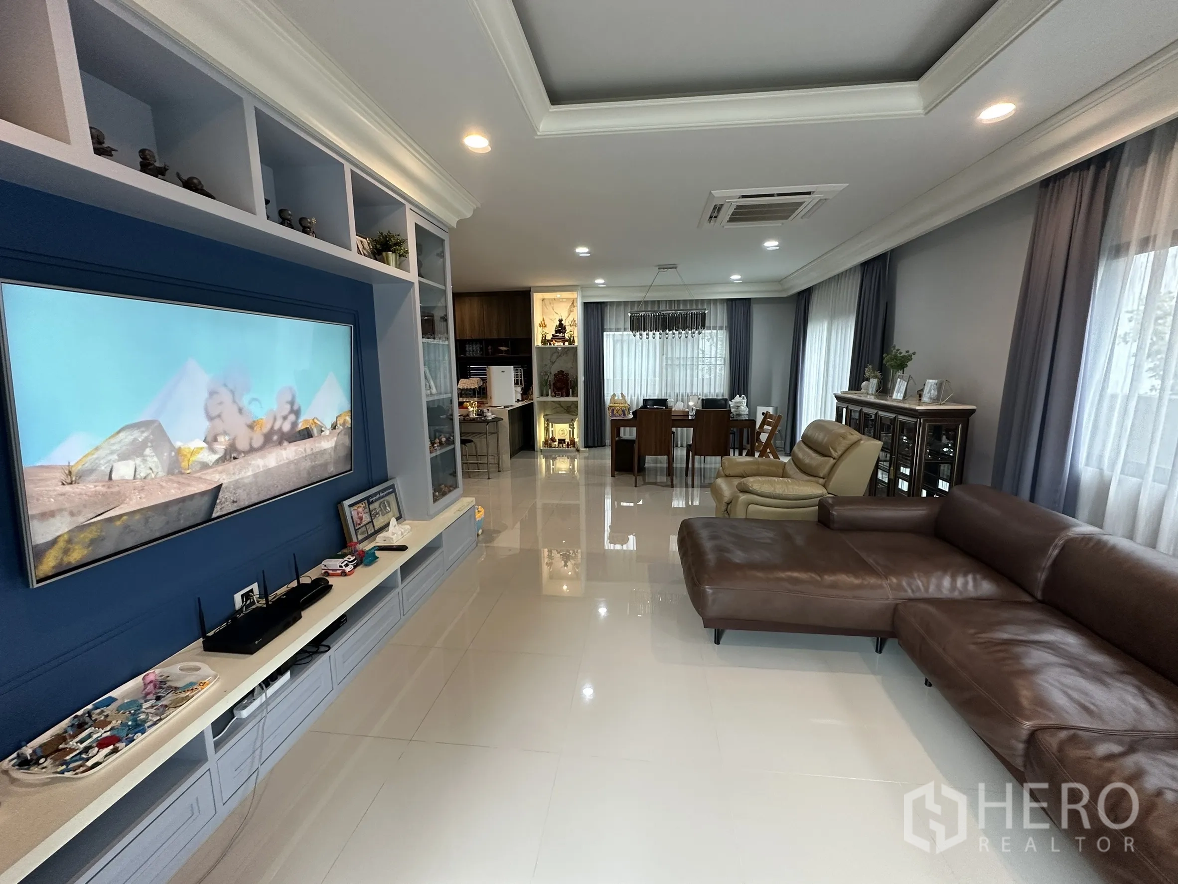 บ้าน ให้เช่าในLam Luk Ka, Pathum Thani - ผนังทีวีพร้อมชั้นวาง มองไปยังพื้นที่ทานอาหารแบบเปิด