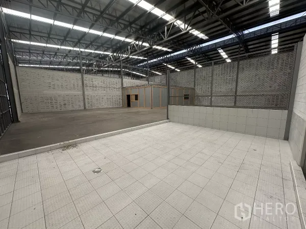 Warehouse for rent in Khlong Toei, Bangkok - Interior warehouse space with a raised tiled loading or washing bay beside open floor.