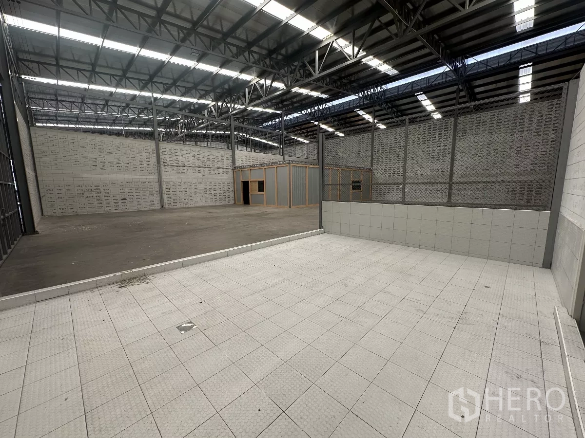 Warehouse for rent in Khlong Toei, Bangkok - Interior warehouse space with a raised tiled loading or washing bay beside open floor.