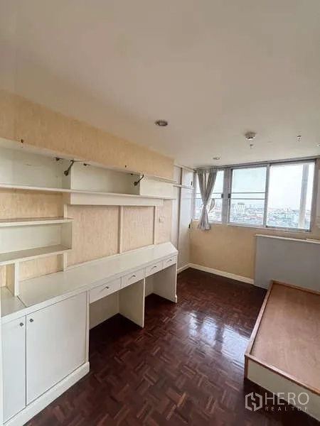 Condominium for rent - Second bedroom or study featuring built-in shelves, a long desk and city views.