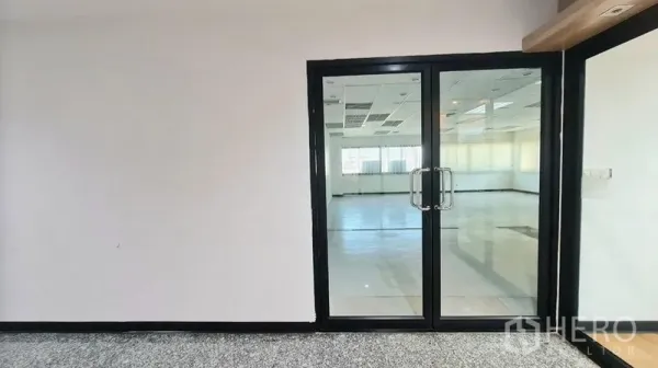 Office Space for rent in Watthana, Bangkok - Black-framed double glass doors opening to a bright open-plan office floor.