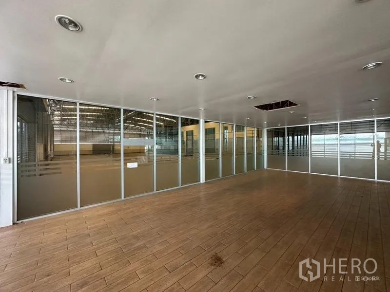 Showroom for rent or sale in Lam Luk Ka, Pathum Thani - Meeting room with wood-look tiles and a full-height glass wall.