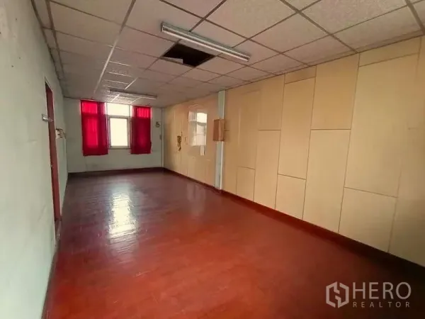 Shophouse for rent in Sathon, Bangkok - Spacious upper-floor room with red curtains, polished wood flooring and drop ceiling, ready for renovation.
