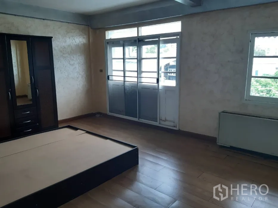 ทาวน์เฮาส์ ให้เช่าในKhlong Toei, Bangkok - ห้องนอนเปิดออกสู่ระเบียงผ่านประตูกระจกสไลด์ พื้นลายไม้