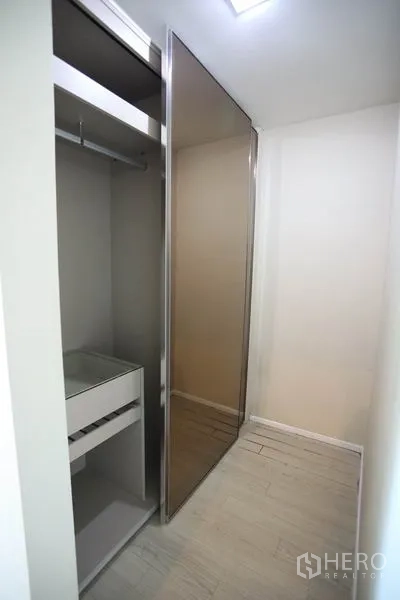 Condominium for rent or sale in Watthana, Bangkok - Walk-in closet with mirrored sliding door and built-in drawers for organized storage.