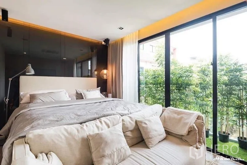 Townhouse for sale in Lak Si, Bangkok - Bedroom opening to a balcony with potted greenery and sliding glass doors.