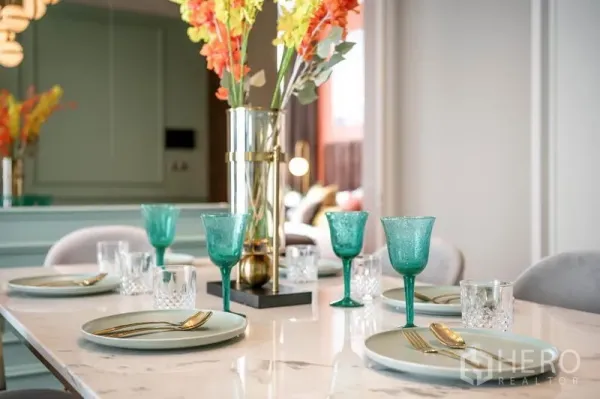 公寓 出租或出售在Watthana, Bangkok - 大理石餐桌特写，绿玻璃杯与花艺摆设。