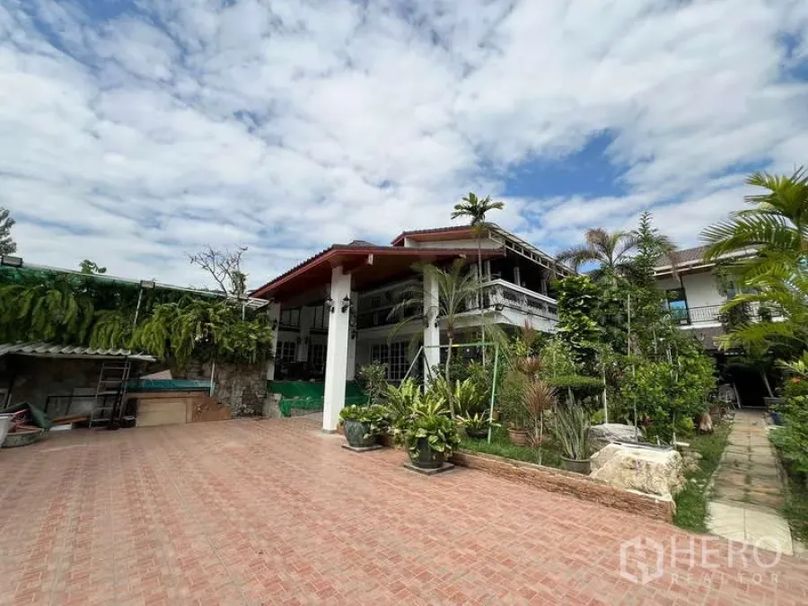 Detached House for rent in Chatuchak, Bangkok - Front exterior of detached house with wide courtyard and tropical plants.