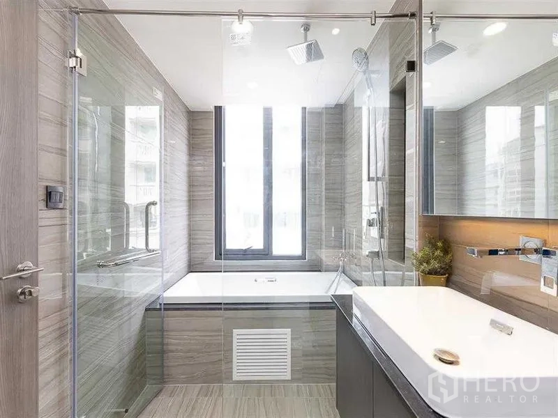 คอนโด ให้เช่าในPathum Wan, Bangkok - ห้องน้ำสไตล์สปา มีตู้กระจก ฝักบัวกระจก และอ่างอาบน้ำลึกพร้อมหน้าต่างสูง