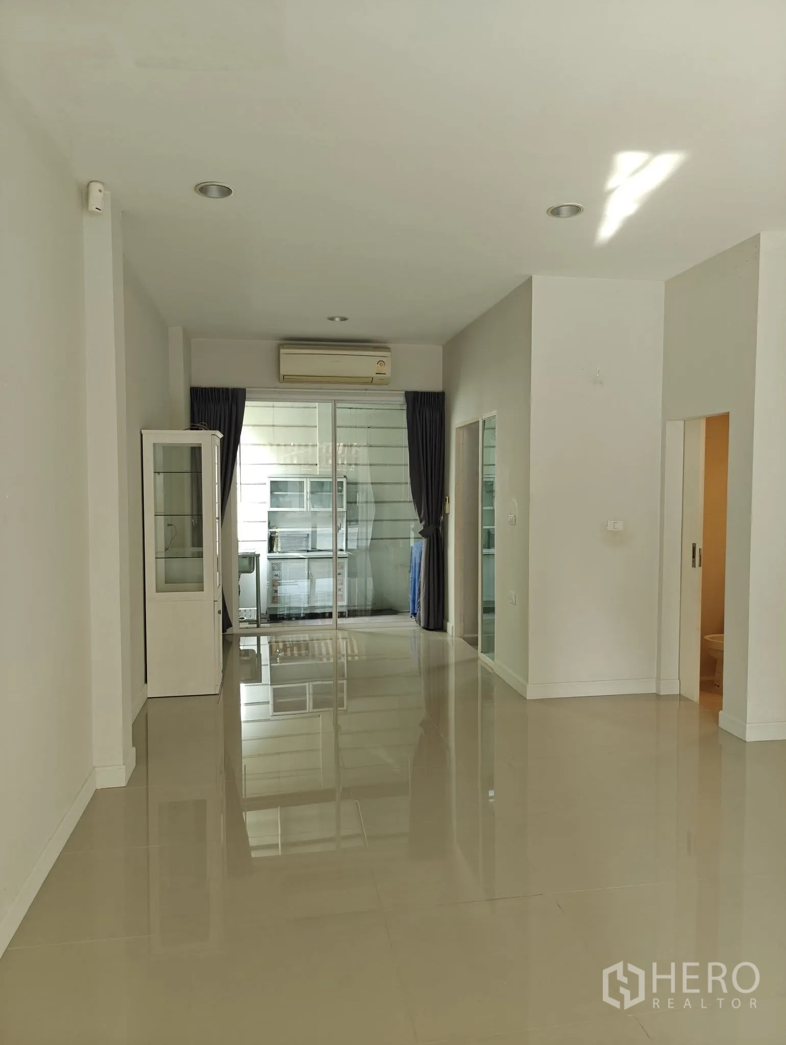 联排别墅 出租或出售在Lat Phrao, Bangkok - 修长的客餐空间，嵌入式照明，后方设推拉门通往厨房。