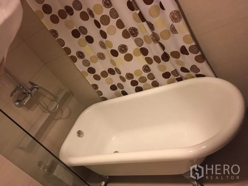 คอนโด ให้เช่าในKhlong Toei, Bangkok - ห้องน้ำพร้อมอ่างอาบน้ำสำหรับแช่ตัว ชุดฝักบัว และม่านลายจุด