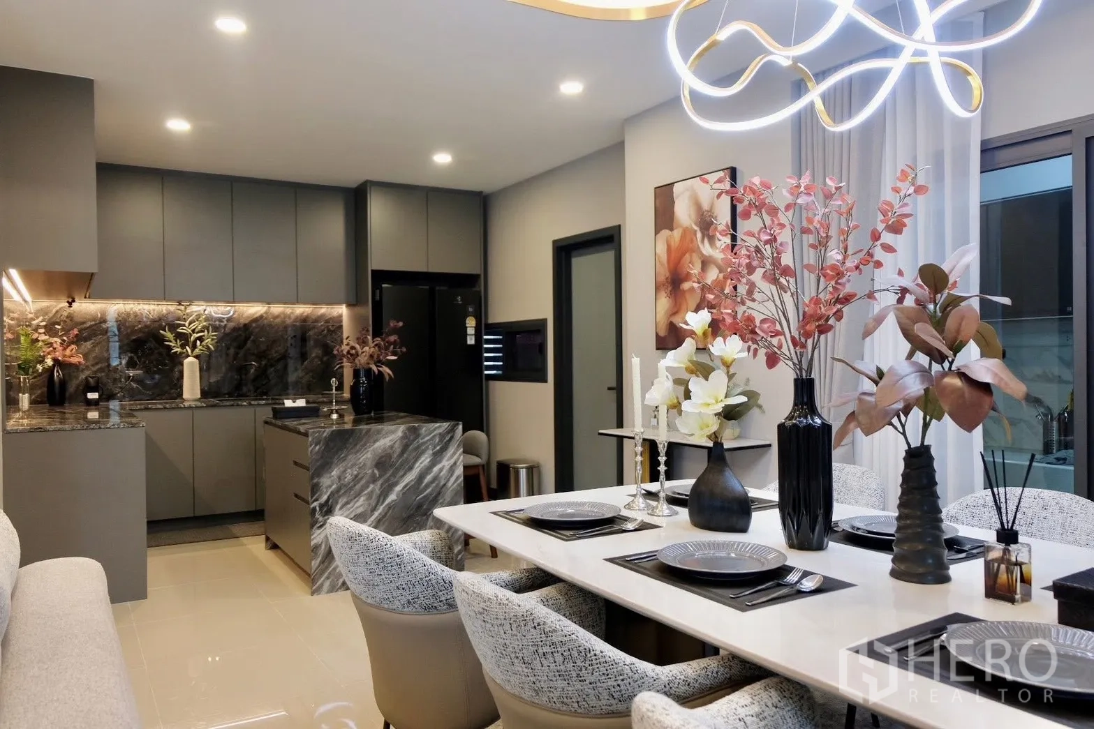 Semi-detached House for sale in Prawet, Bangkok - Dining area set for six next to the designer kitchen and chandelier.
