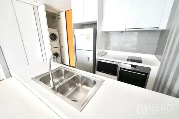 公寓 出租或出售在Watthana, Bangkok - 紧凑厨区，双槽水槽、灶台、烤箱、冰箱及叠放洗烘一体机。