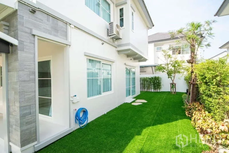 Detached House for rent in Bang Phli, Samut Prakan - Private backyard with artificial turf, trees and hedges around the house.