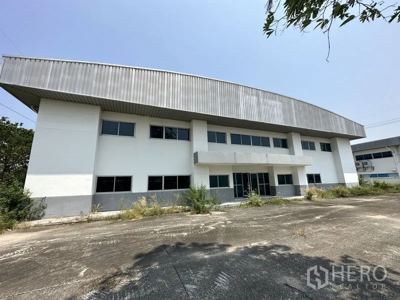 โรงงาน ให้เช่าในChon Buri - ด้านหน้าอาคารโรงงาน พร้อมประตูกระจกและลานจอดรถ