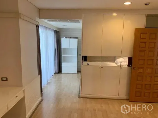 คอนโด ให้เช่าในPathum Wan, Bangkok - พื้นที่สว่างมีตู้เสื้อผ้าบิลท์อินสีขาว หน้าต่างบานใหญ่พร้อมม่านโปร่ง และพื้นไม้สีอ่อน