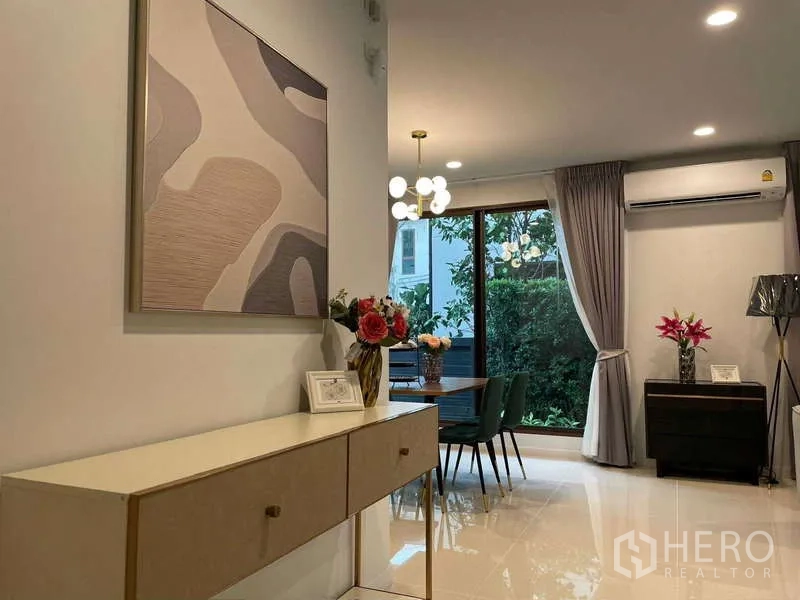 Detached House for rent in Bang Kapi, Bangkok - Open-plan dining area with chandelier, console and garden view.