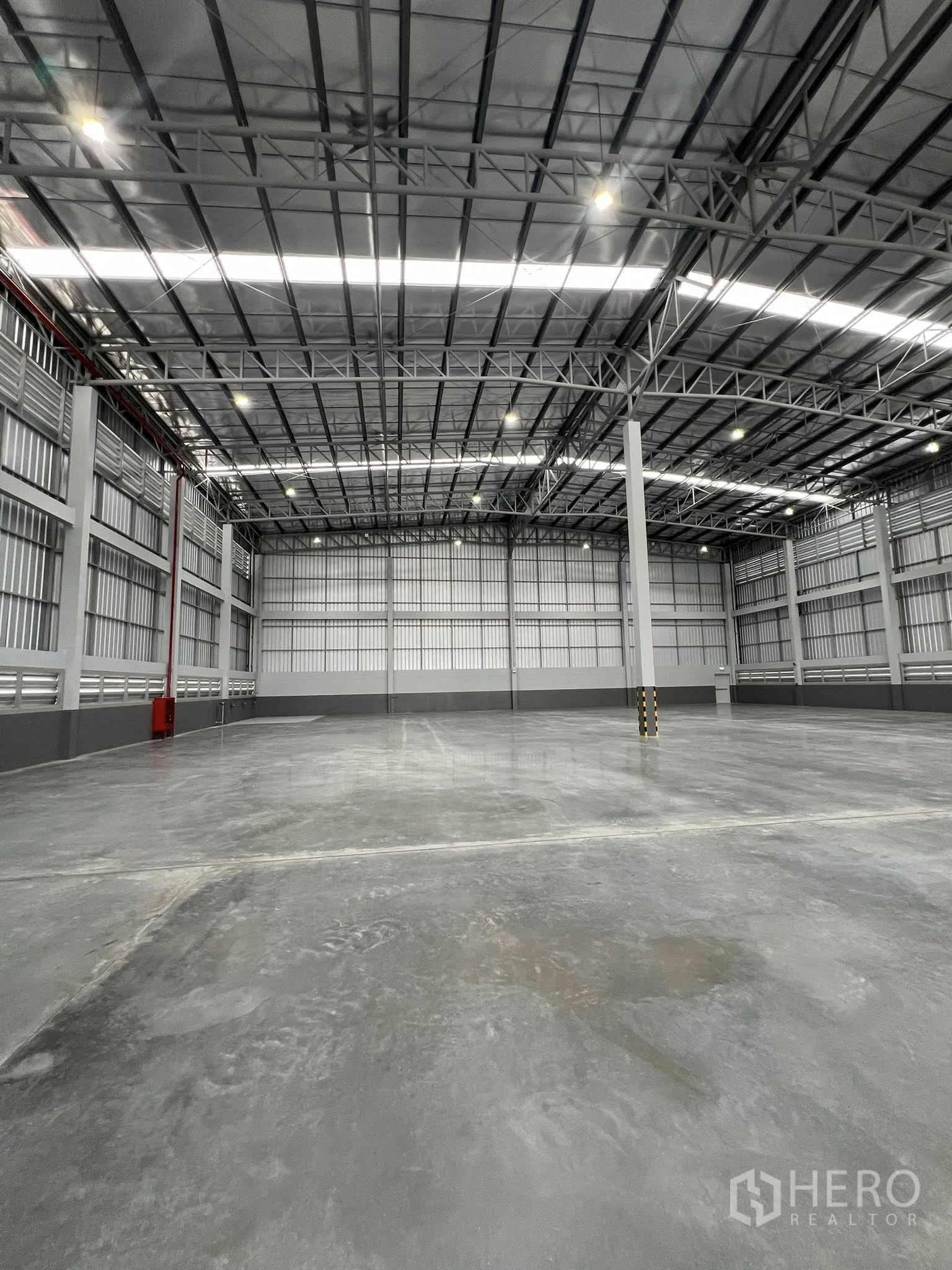 Warehouse for rent in Phra Pradaeng, Samut Prakan - Open warehouse space with steel structure and overhead lighting.