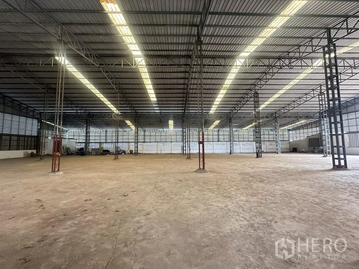 Warehouse for sale in Nong Chok, Bangkok - Expansive warehouse interior with high metal roof, skylights and steel columns, ideal for storage or production.