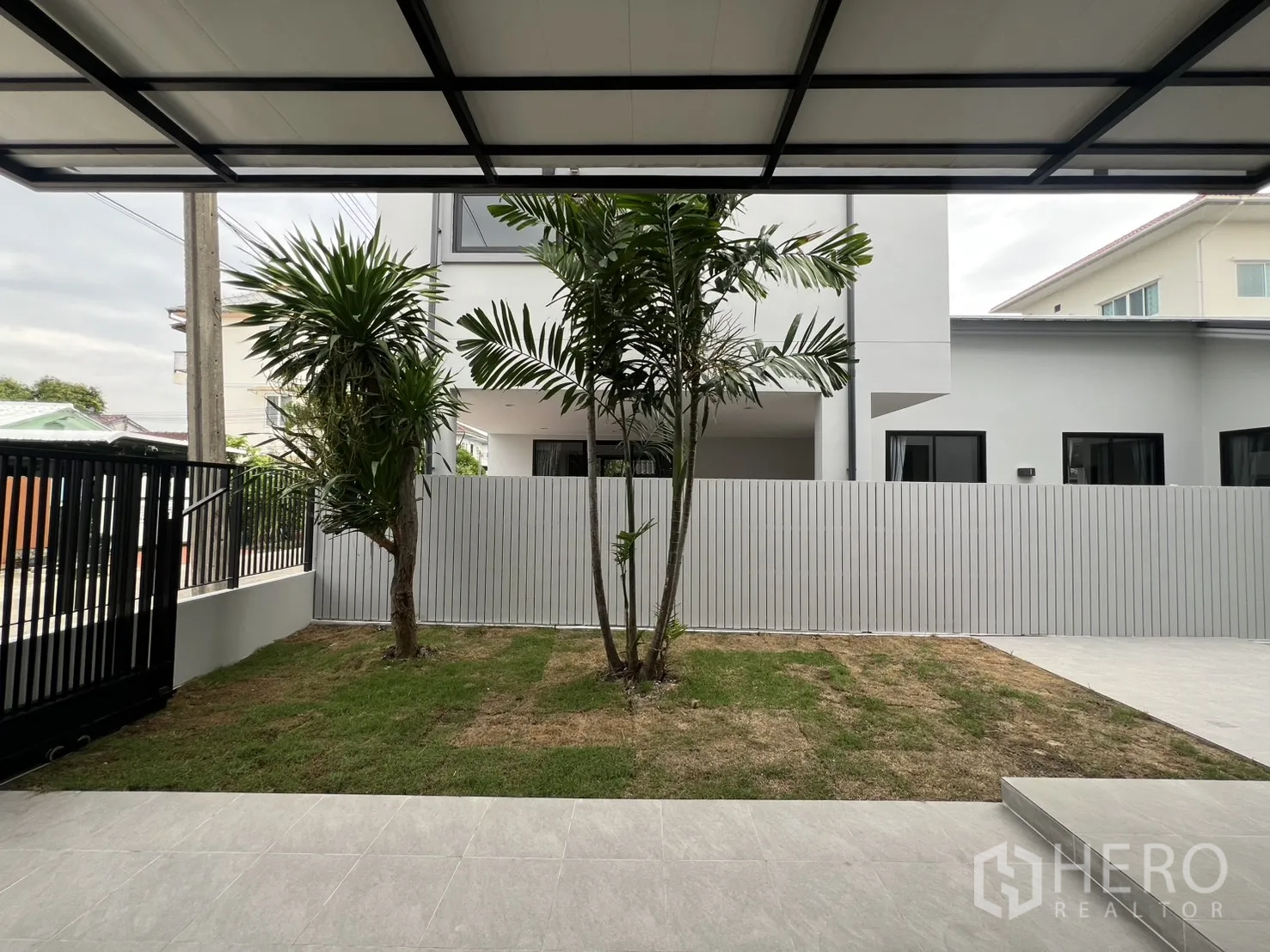 Detached House for rent in Saphan Sung, Bangkok - Covered terrace and driveway beside house with wide tiled surface.