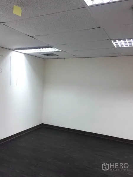 สำนักงาน ให้เช่าในWatthana, Bangkok - มุมห้องออฟฟิศว่าง ผนังสีขาว พื้นไวนิลสีเข้ม และไฟเพดานแบบฝัง