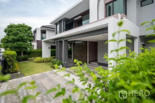 Detached House for rent in Prawet, Bangkok - Modern two-storey detached house with covered carport, driveway and landscaped front garden.