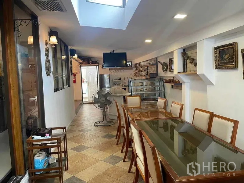 店屋 出租在Phaya Thai, Bangkok - 茶水间与用餐区，长桌、展示柜与天窗采光。