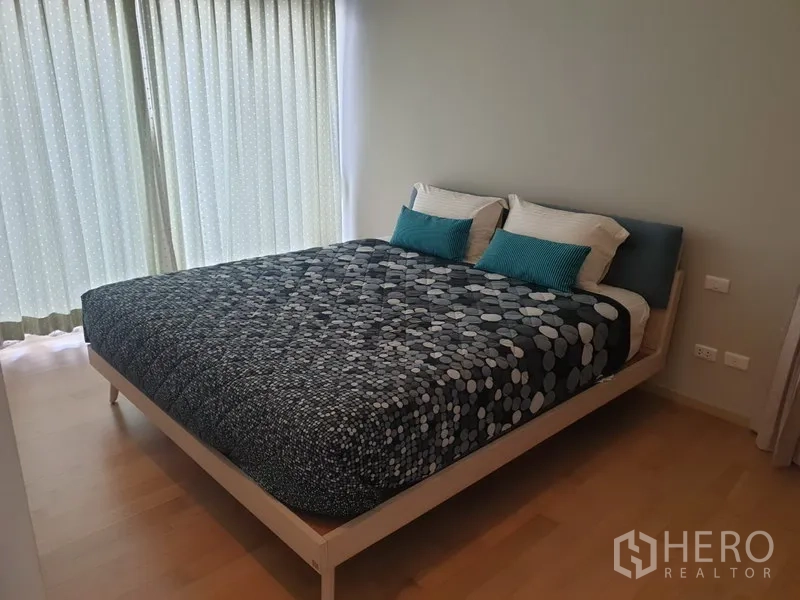 คอนโด ให้เช่าหรือขายในWatthana, Bangkok - ห้องนอนอบอุ่น เตียงขนาดใหญ่ พื้นไม้ และหน้าต่างสูงจรดเพดานพร้อมผ้าม่าน