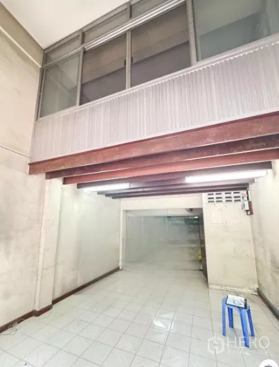 店屋 出租在Watthana, Bangkok - 一层店面大厅，白色地砖、外露木梁与上方玻璃窗。