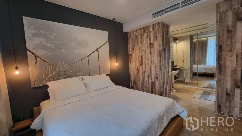 คอนโด ให้เช่าในWatthana, Bangkok - มุมมองห้องนอนแสดงโคมไฟห้อย ผิวไม้ และตู้เสื้อผ้าบานกระจก