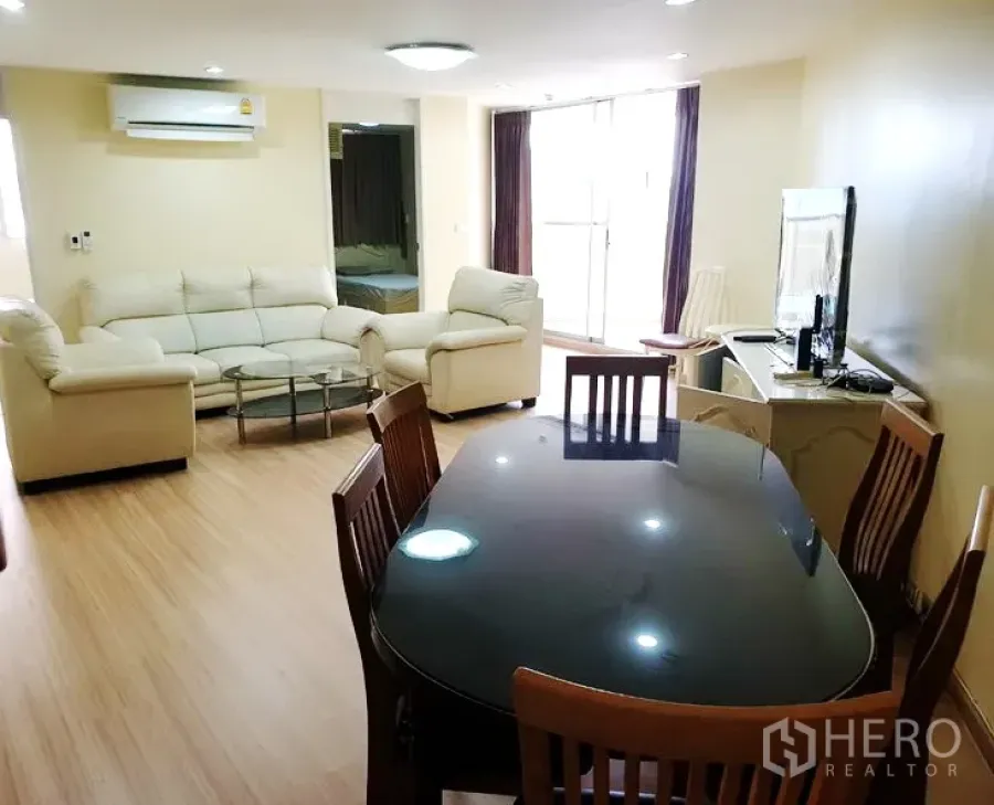 คอนโด ให้เช่าในWatthana, Bangkok - ห้องนั่งเล่นและรับประทานอาหารสว่าง เฟอร์นิเจอร์หนังสีครีม โต๊ะกระจก โต๊ะทานข้าวไม้ ทีวี และประตูระเบียง