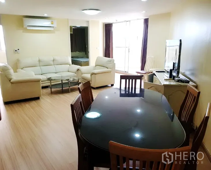 คอนโด ให้เช่าในWatthana, Bangkok - ห้องนั่งเล่นและรับประทานอาหารสว่าง เฟอร์นิเจอร์หนังสีครีม โต๊ะกระจก โต๊ะทานข้าวไม้ ทีวี และประตูระเบียง