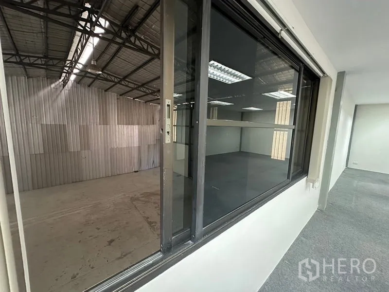 Office Space for rent - Interior corridor looking through glass into the adjoining warehouse hall.